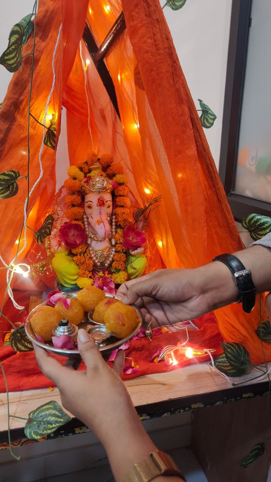 Prasad being offered to the Ganesh idol under festive lights at TradeAura Institute