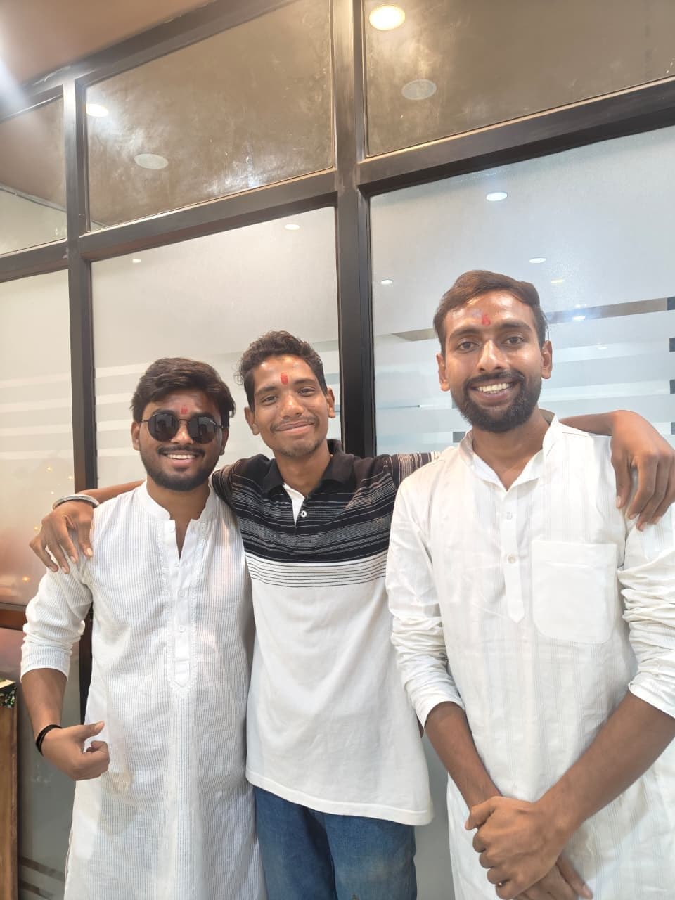 Three TradeAura team members in kurtas posing together at the institute