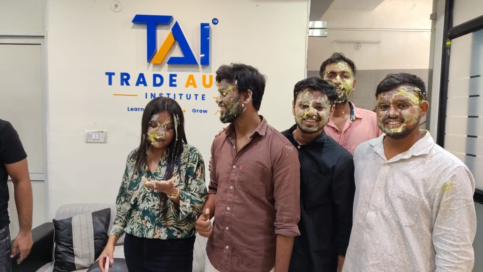 TradeAura students and mentors celebrating a birthday with cake and decorations at the institute
