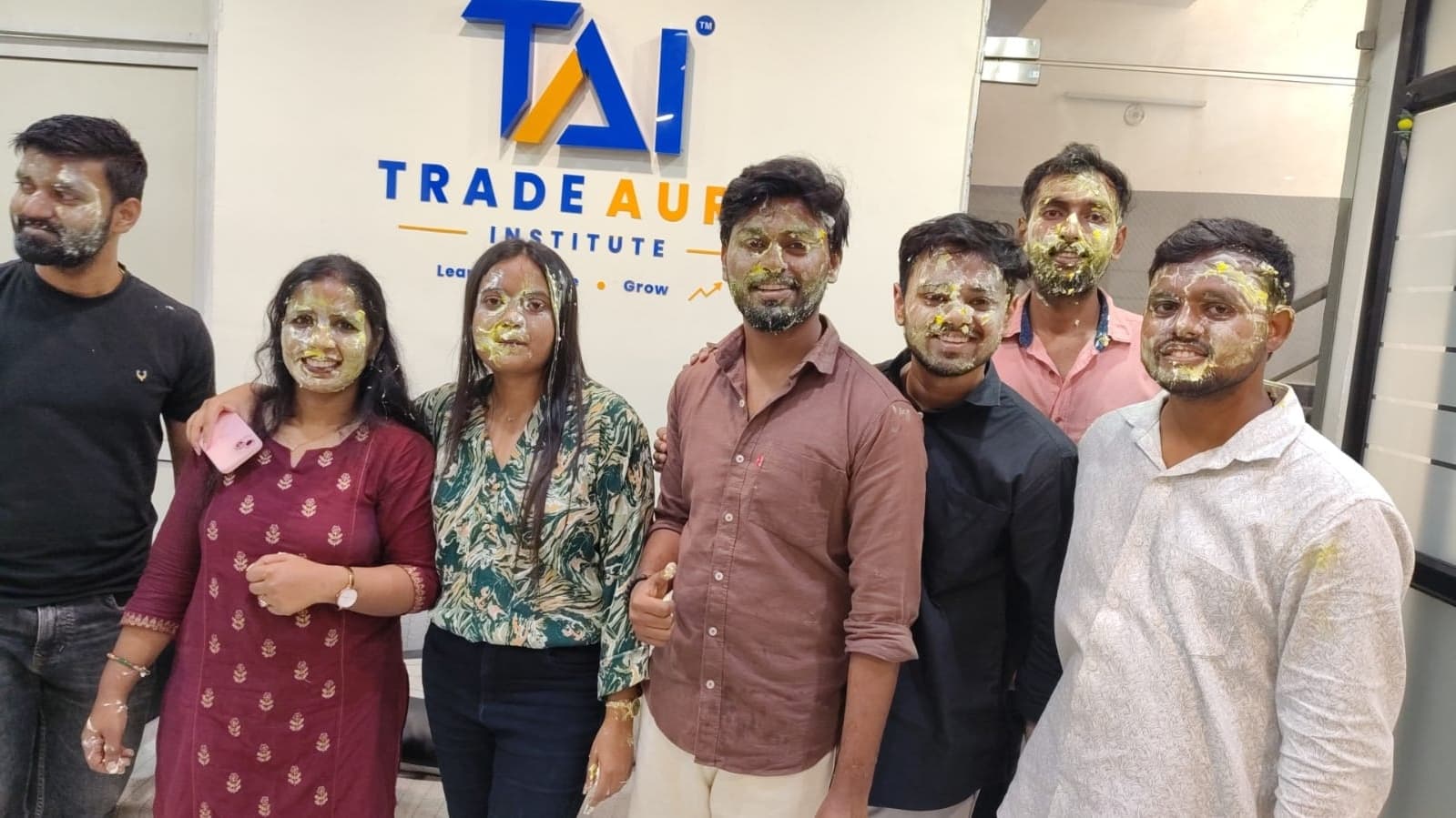 TradeAura mentors and students posing together during a birthday celebration